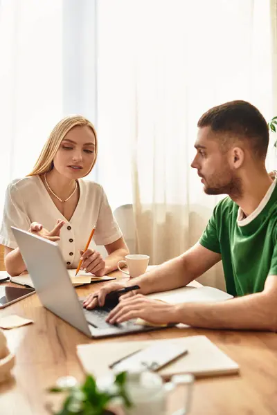 Loving couple engaged in a thoughtful discussion while working together at their dining table. — Stock Photo