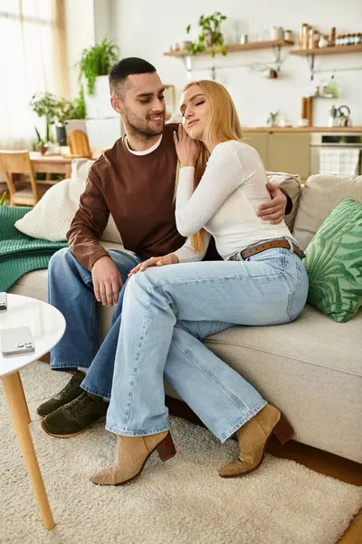 Pareja disfruta de la compañía de los demás mientras se relaja en un cómodo sofá en su casa. - foto de stock