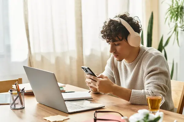 Handsome man immersed in his mobile device, surrounded by a warm, inviting atmosphere. — Stock Photo