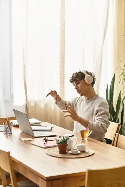 Bell'uomo con i capelli ricci si impegna appassionatamente nella musica mentre lavora alla sua scrivania. — Foto stock