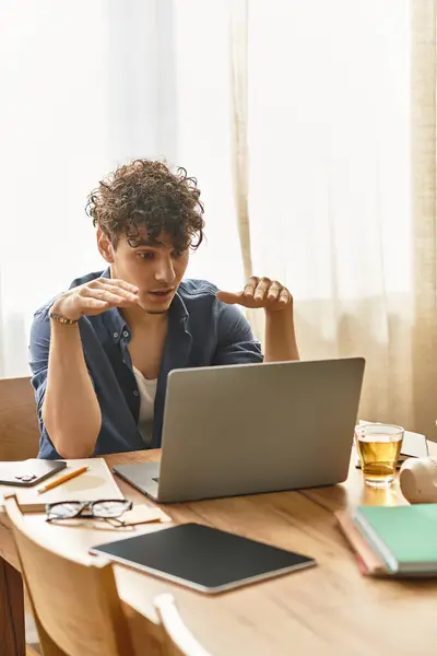 Young man expresses enthusiasm while connecting with others through technology in a warm setting. — Stock Photo