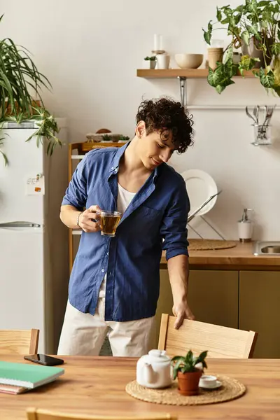 Young man in a modern kitchen brews tea, creating a warm and inviting vibe. — Stock Photo
