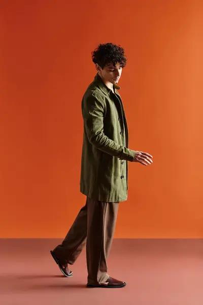 Handsome man strolls gracefully in a trendy outfit, perfectly paired with a striking background. — Stock Photo