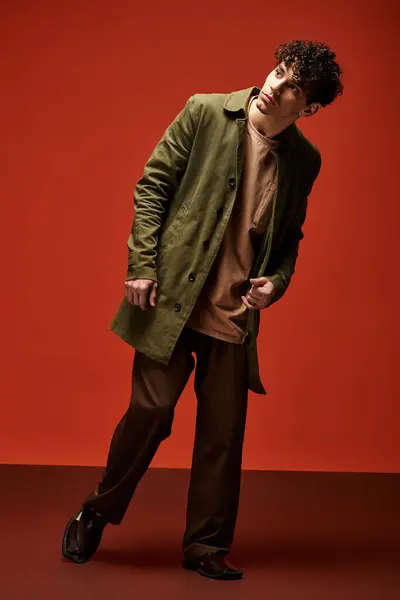 Handsome young man displays confidence while showcasing a fashionable look in a striking setting — Stock Photo