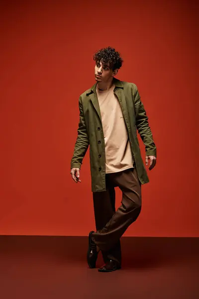 A handsome man in a stylish outfit exudes charm against a bold backdrop. — Stock Photo