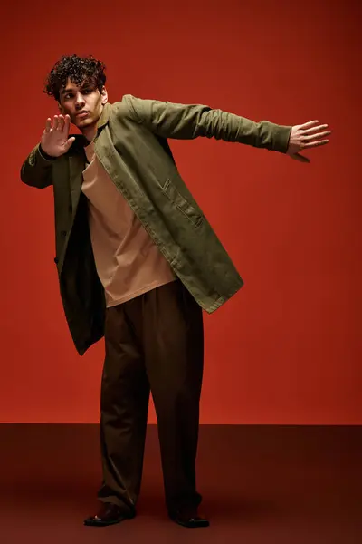 Handsome man strikes a captivating pose wearing a stylish outfit in a bright, bold setting. — Stock Photo