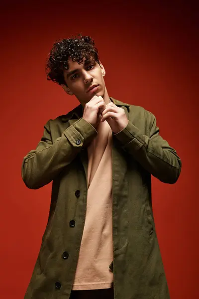 Handsome man poses confidently, showcasing his chic style against a striking red background. — Stock Photo