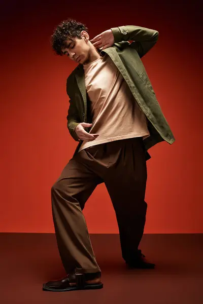 Handsome man showcases a bold fashion statement in a striking indoor space, feeling the rhythm. — Stock Photo