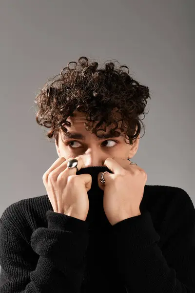 A stylish young man hides his smile while showing off his fashionable outfit and accessories. — Stock Photo