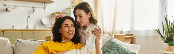 Two women express affection while relaxing at home, enjoying each others company and laughter. — Stock Photo