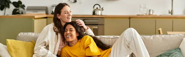 Zwei Frauen umarmen sich lächelnd und genießen einen gemütlichen Nachmittag zu Hause zusammen. — Stockfoto