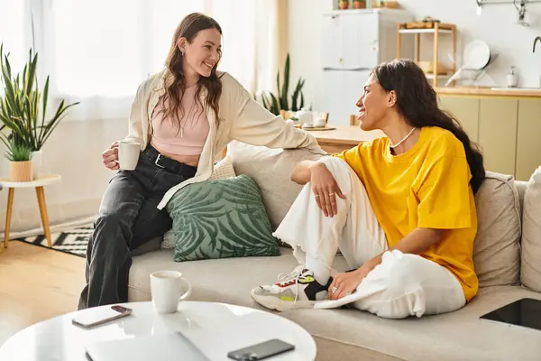Two women embrace a tender moment in their cozy living room, radiating love and joy. — Stock Photo