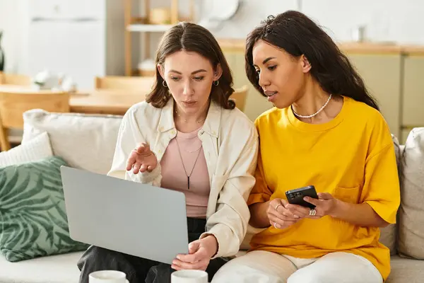 Two women connect deeply while reviewing exciting ideas on a laptop in their cozy living space. — Stock Photo