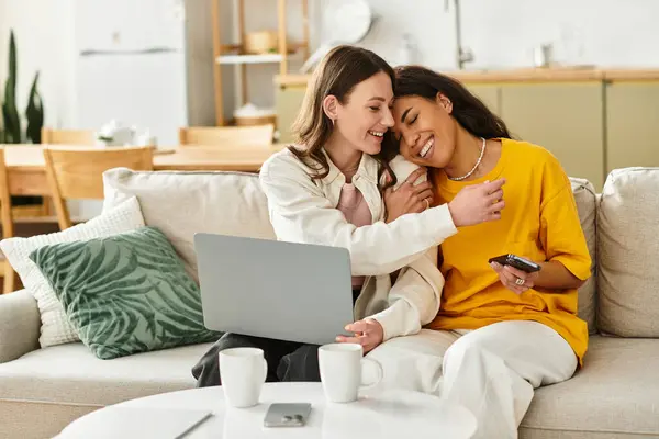 Deux femmes se détendent ensemble à la maison, riant et embrassant alors qu'elles profitent de leur connexion intime. — Photo de stock