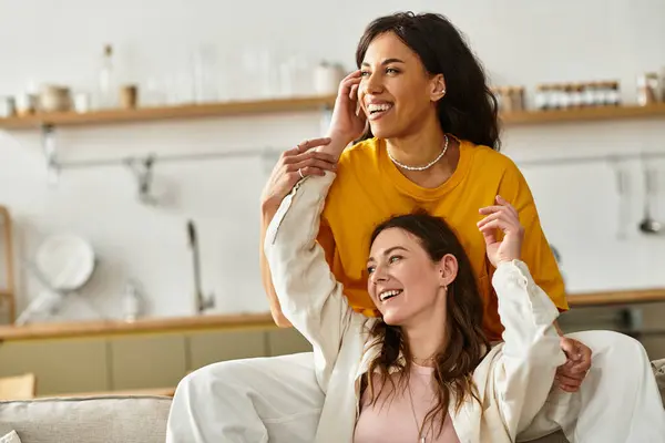 Two women embrace in a warm moment, smiling and enjoying each others company at home. — Stock Photo