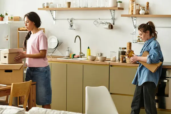 Two women enjoy a heartfelt moment as they unpack and organize their shared living space. — Stock Photo