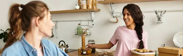 Two women share laughter and joy while cooking in their warm, inviting kitchen. — Stock Photo