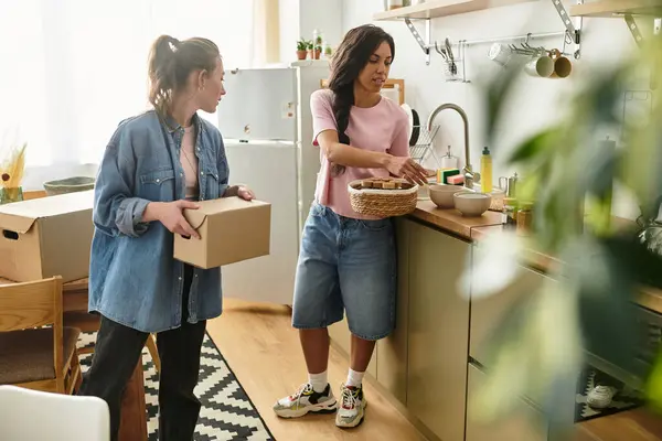 Two cheerful women unpack and share moments in their cozy kitchen filled with love and laughter. — Stock Photo