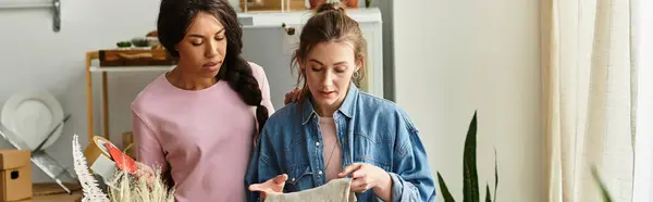 Two women share a tender moment as they discuss a creative project in their cozy living space. — Stock Photo