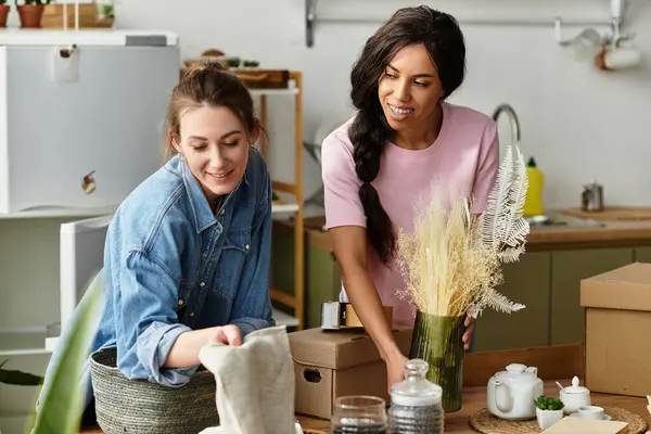 Deux femmes apprécient la compagnie de l'autre alors qu'elles organisent un décor dans leur espace de vie accueillant. — Photo de stock