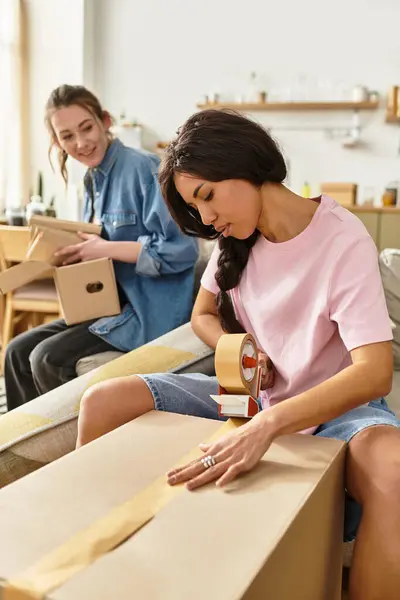 Zwei liebende Frauen teilen einen freudigen Moment, als sie ihre Sachen für ein neues Kapitel im Leben packen. — Stockfoto