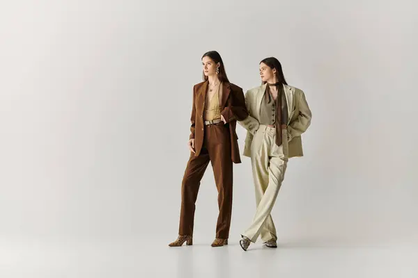 Twin sisters showcase their fashion forward outfits while enjoying a moment of bonding together. — Stock Photo