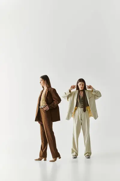 Beautiful twin sisters express their unique styles while bonding in a chic studio environment. — Stock Photo