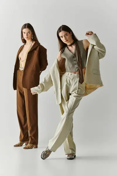 Two lovely twin sisters flaunt unique fashion styles in playful poses and confident looks. — Stock Photo