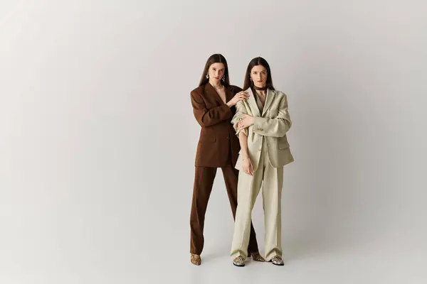 Twin sisters exude confidence and style, posing together in chic outfits and heels. — Stock Photo