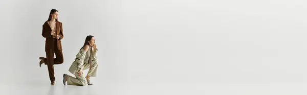 Zwillingsschwestern bringen ihren einzigartigen Stil zum Ausdruck, während sie sich in einem minimalistischen Umfeld verbinden. — Stockfoto
