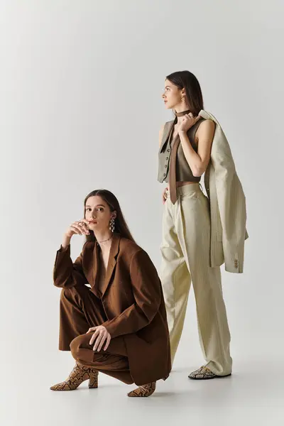 Twin sisters express their unique styles through chic outfits, exuding confidence and grace. — Stock Photo