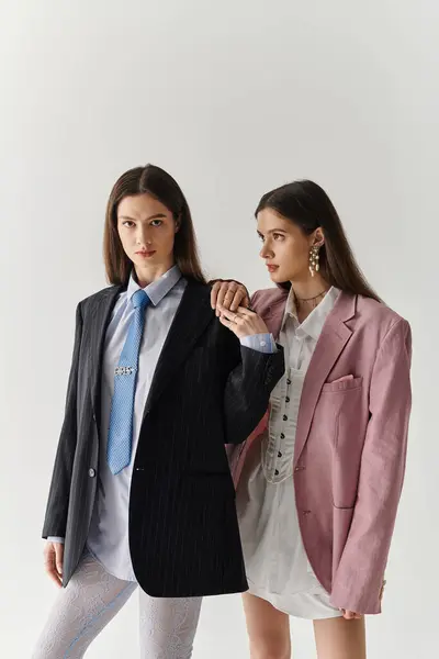 Two stylish twin sisters showcase their unique looks in fashionable outfits. — Stock Photo