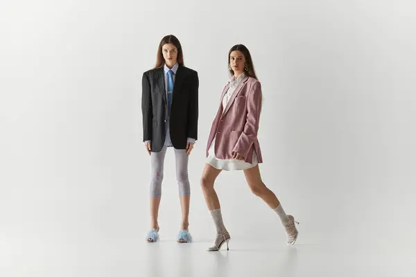 Modebewusste Zwillingsschwestern versprühen Charme und Kreativität, während sie stilvoll im Atelier posieren. — Stockfoto