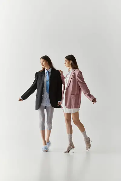 Twin sisters express their strong bond and individual styles while posing together elegantly. — Stock Photo