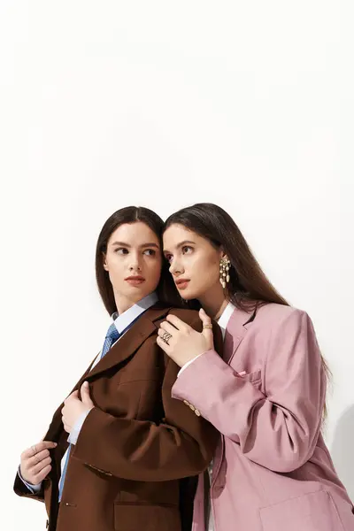 Twin sisters dressed in chic blazers exude elegance while sharing a moment of connection. — Stock Photo