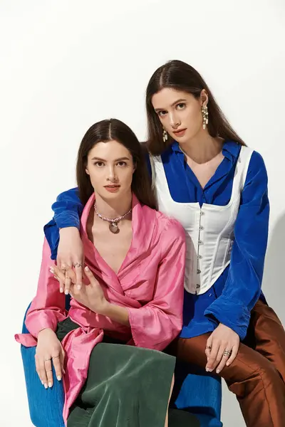 Hermosas hermanas gemelas comparten un momento en un estudio elegante, irradiando elegancia y amor fraternal. — Stock Photo