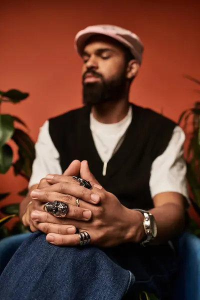 Young man showcases summer fashion with accessories, exuding confidence in a cozy atmosphere. — Stock Photo