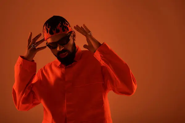 Un jeune homme met en valeur le style estival, respirant la confiance dans une tenue et des accessoires orange audacieux. — Photo de stock