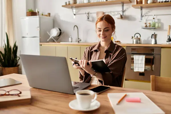 Bright kitchen setting features a red haired woman engaged in thoughtful writing and inspiration. — Stock Photo