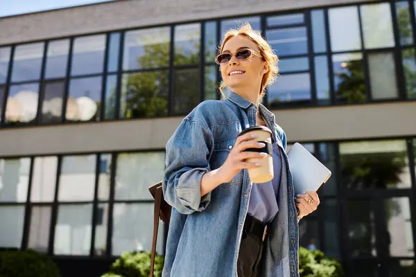 Radiating positivity, a red haired woman strolls outdoors while sipping coffee and holding a tablet. — Stock Photo