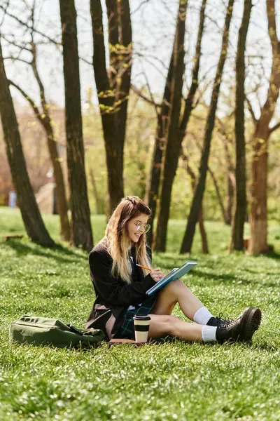 A young adult college student enjoys her studies outdoors, surrounded by nature. — Stock Photo