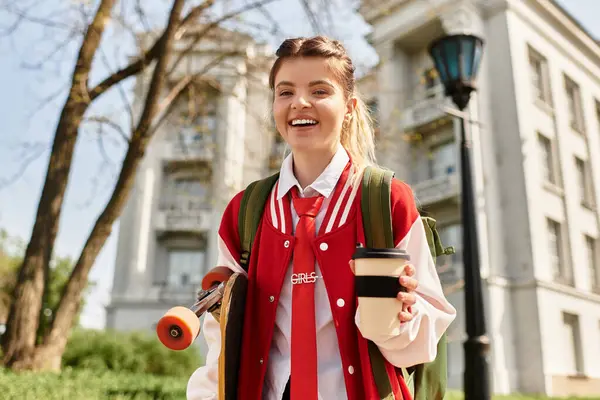 A cheerful college girl strolls campus in her trendy outfit and vibrant bomber jacket. — Stock Photo