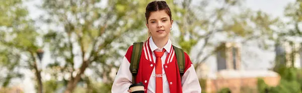 A young adult student walks through campus, carrying coffee and wearing a trendy outfit, banner — Stock Photo