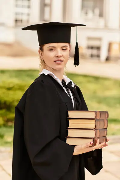 A young college graduate proudly holds her books, ready to embrace new opportunities. — Stock Photo