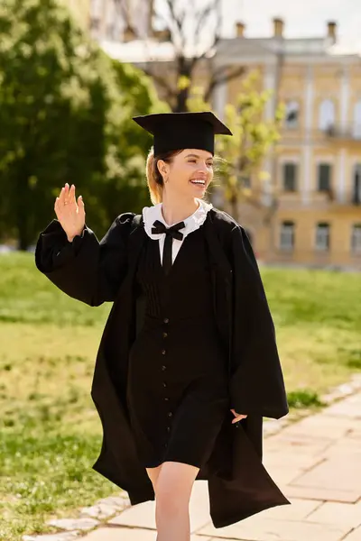 Un gioioso collegio onde laureati mentre si cammina attraverso un ambiente vibrante campus all'aperto. — Foto stock