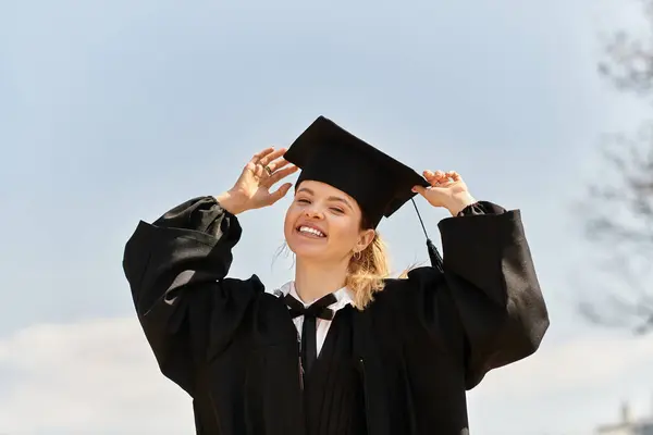 College girl indossa un abito di laurea e cappello irradia felicità mentre celebra il successo. — Foto stock