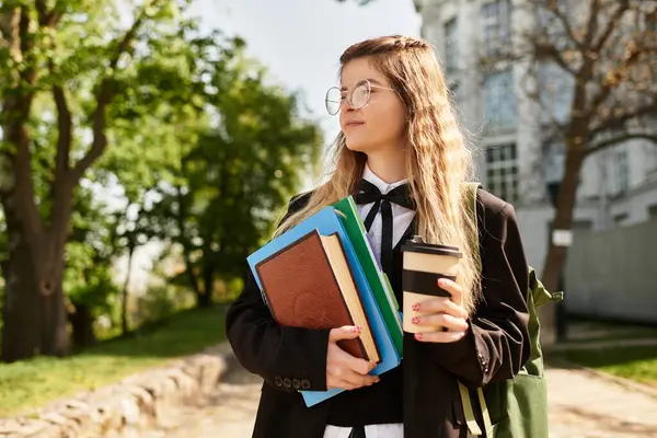 A pretty young adult wears a stylish uniform while savoring a coffee amidst greenery. — Stock Photo