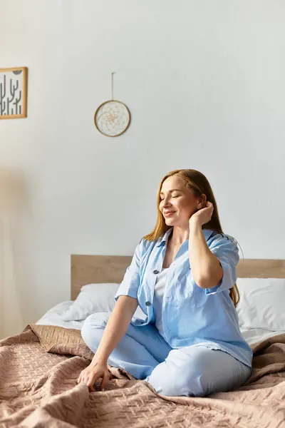 Eine schöne junge Frau sitzt auf ihrem Bett und genießt einen friedlichen Moment in ihrem gemütlichen Zimmer. — Stockfoto