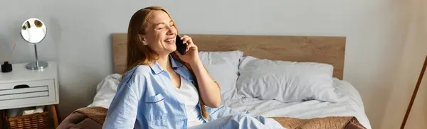 Junge Frau entspannt zu Hause, während sie mit einem strahlenden Lächeln und gemütlicher Atmosphäre telefoniert. — Stockfoto