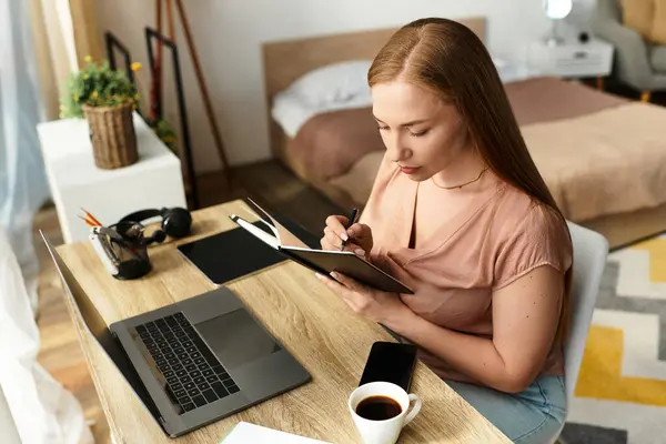 Una giovane donna scrive nel suo quaderno, persa nel pensiero in una casa accogliente. — Foto stock